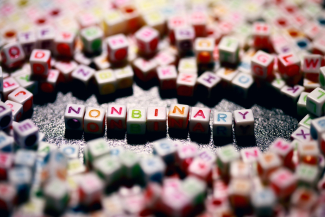 Würfelbuchstaben zeigen das Wort "nonbinary"