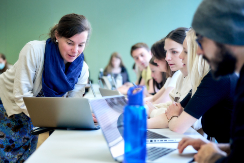 Dozentin erklärt Studierenden etwas am Laptop