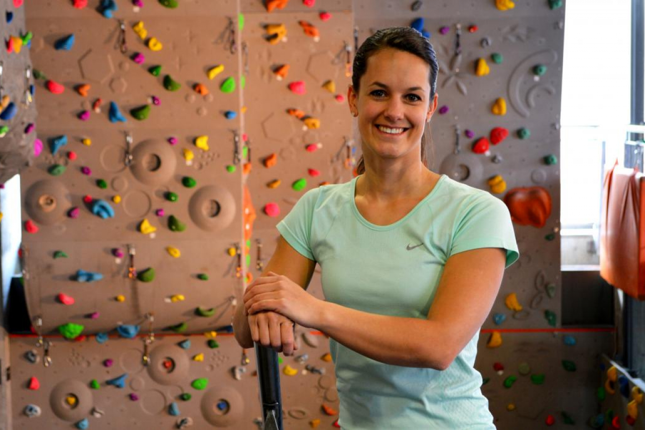 Manuela Catillaz, Sportlehrerin an einer Berufsmaturitätsschule, steht vor einer Kletterwand.
