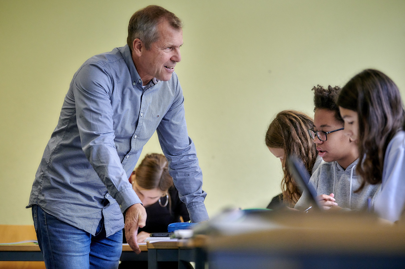 Lehrperson iteragiert mit Schülerinnen und Schülern.