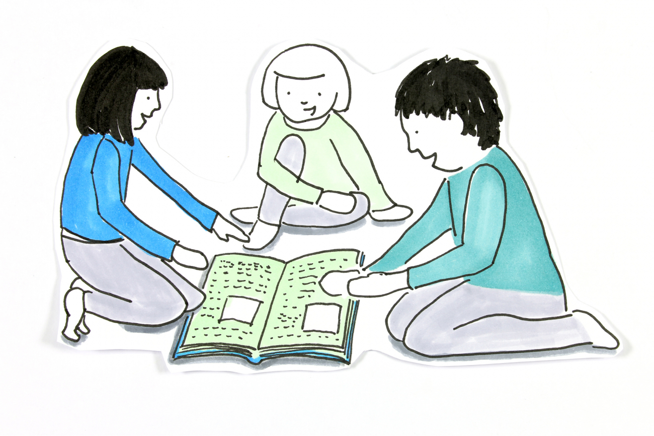 Drei Kinder sitzen um offenes Buch