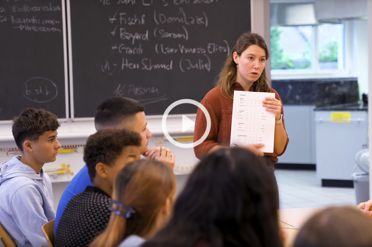 Céline steht vor der Klasse und zeigt ihnen etwas