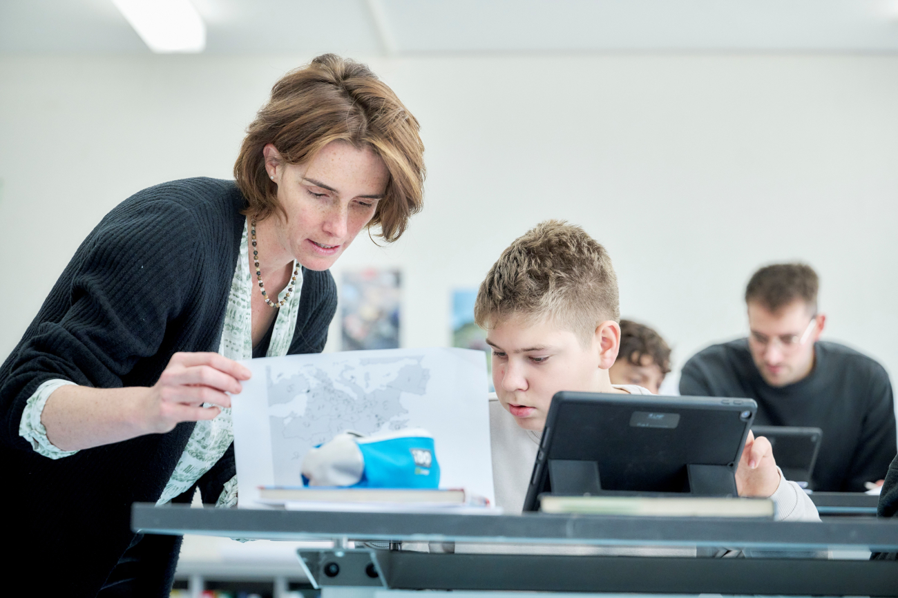 Lehrerin unterstützt einen Schüler beim Lernen