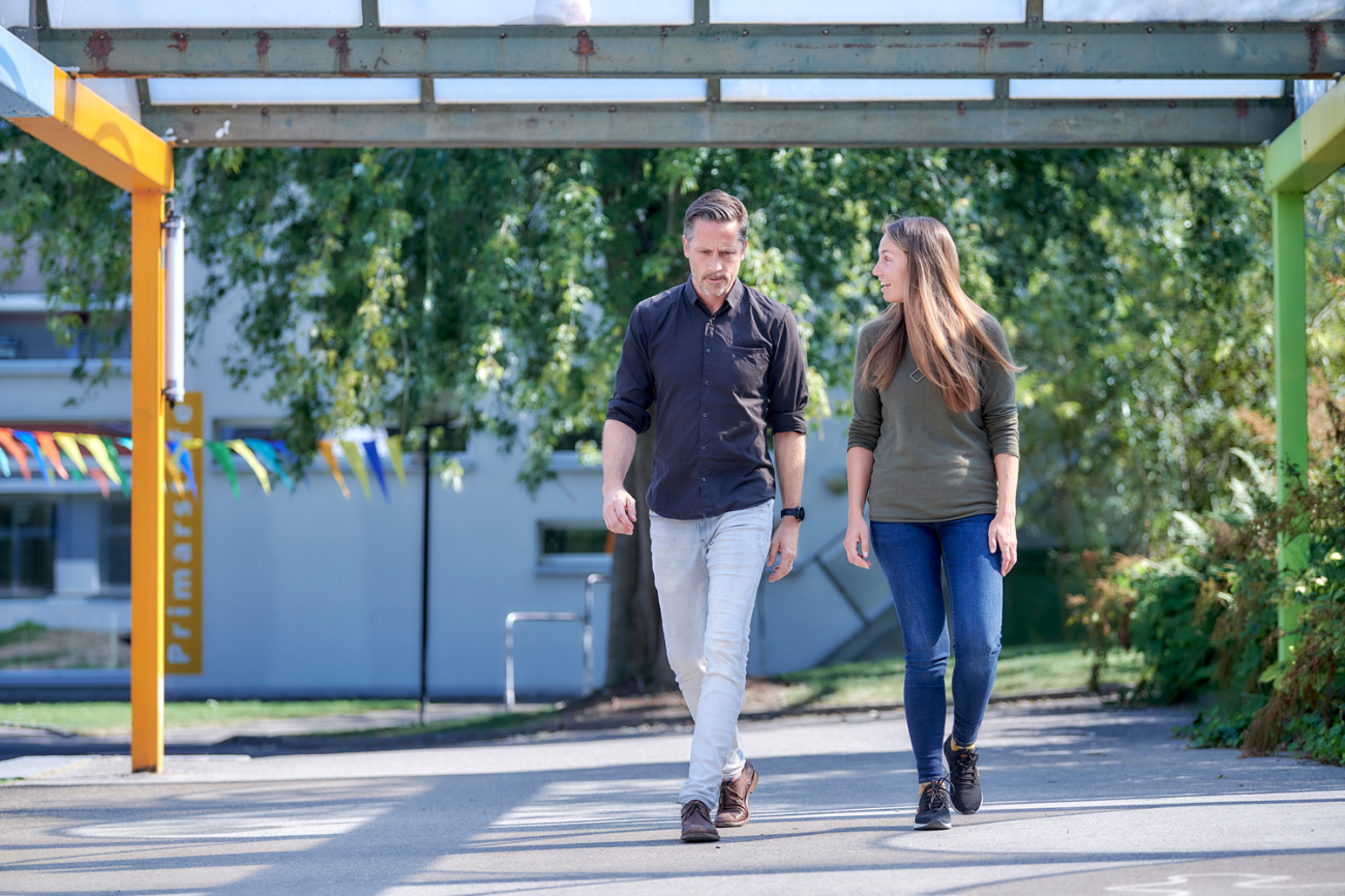 Mann und Frau im Gleichschritt auf Schulgelände