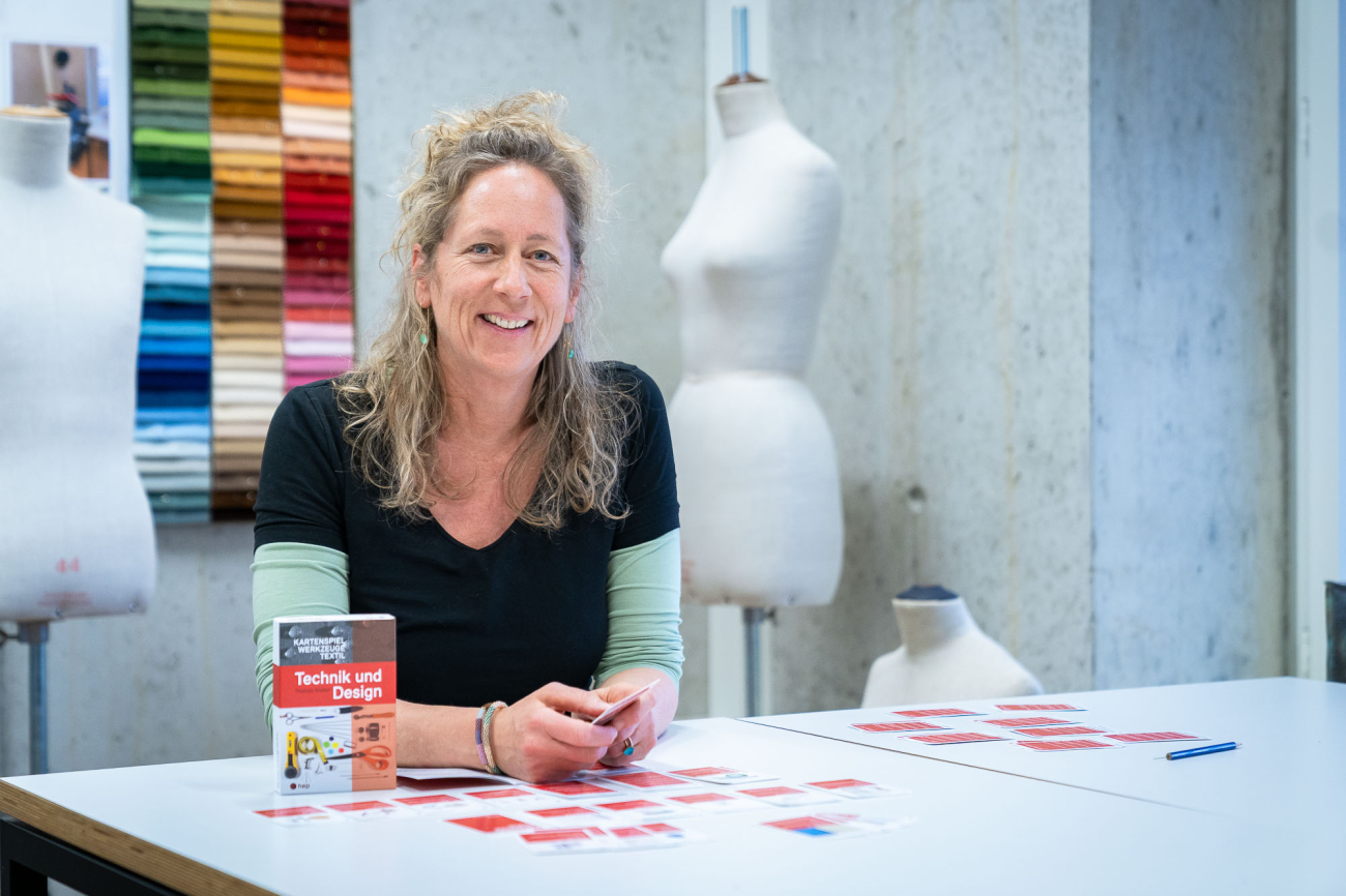 Frau sitzt an Tisch mit Büsten im Hintergrund