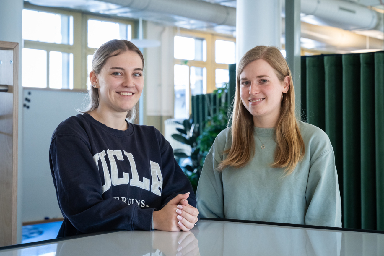 Zwei junge Frauen stehen an einem Stehtisch