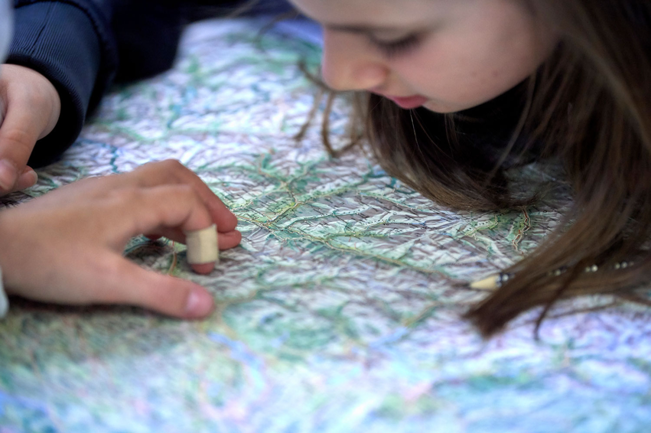 Kind gebeugt über einer Landkarte