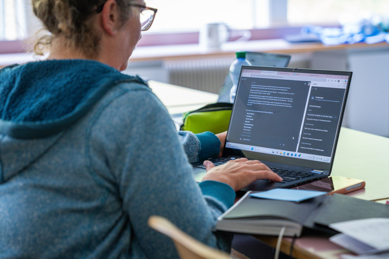 Frau vor Labtop, auf dem ein KI-Programm geöffnet ist