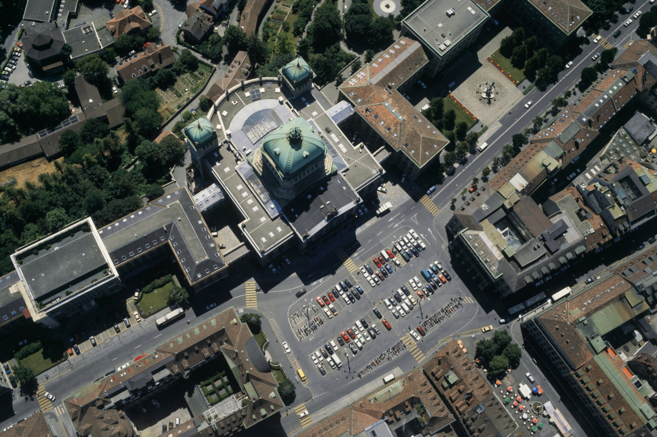 Bundehaus mit den Flügeln West und Ost, Bundesplatz (noch nicht umgestaltet), links: Nationalbank, rechts: Berner Kantonalbank, unten rechts: Bärenplatz mit Marktständen, 1995
