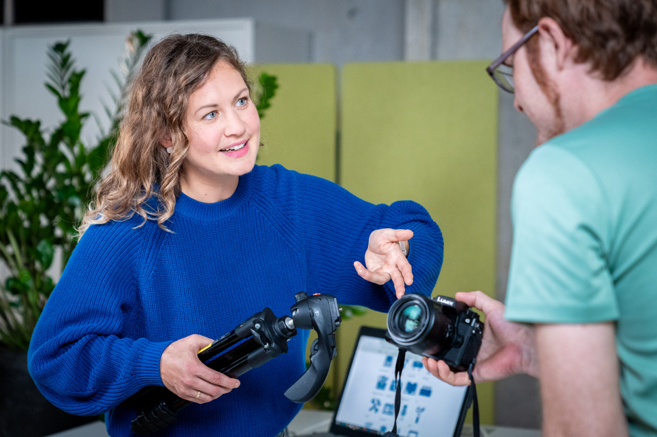 Frau erklärt Mann eine Kamera