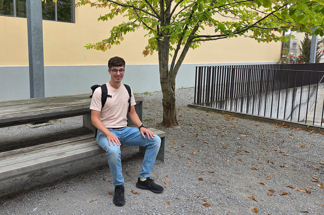Ein Student sitzt auf einer Bank
