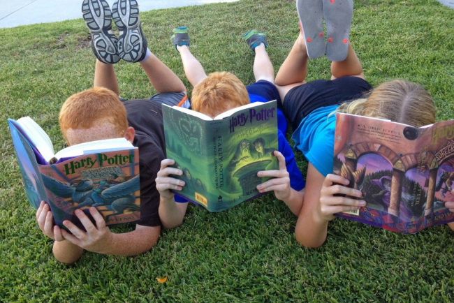 Kinder beim Lesen im Gras