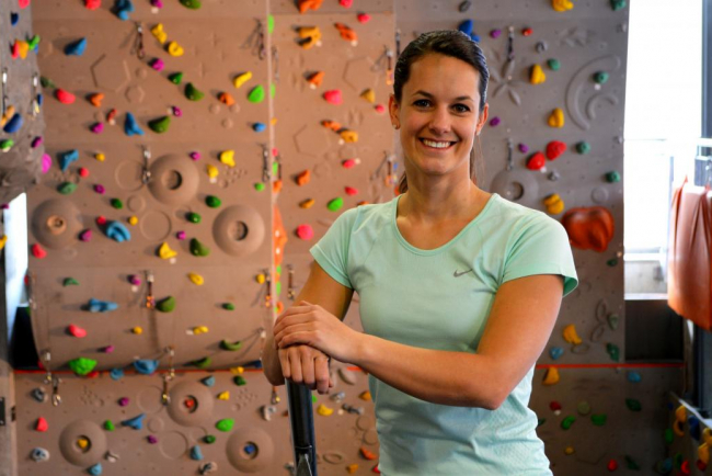 Manuela Catillaz, Sportlehrerin an einer Berufsmaturitätsschule, steht vor einer Kletterwand.