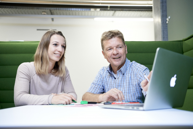 Studierende und Dozent bei Besprechung.