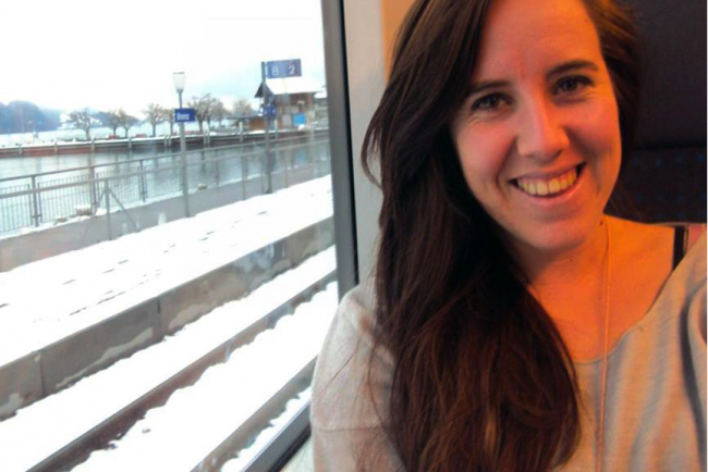 Sarah Cullen, eine Studentin aus Südafrika, die an der PHBern studiert hat. Sie sitzt im Zug, im Hintergrund sind Schnee und ein See zu sehen