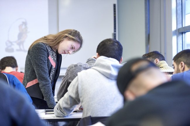 Studierende interagiert mit Schülerinnen und Schülern