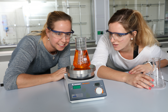 Zwei Studentinnen beobachten ein Reagenzglas