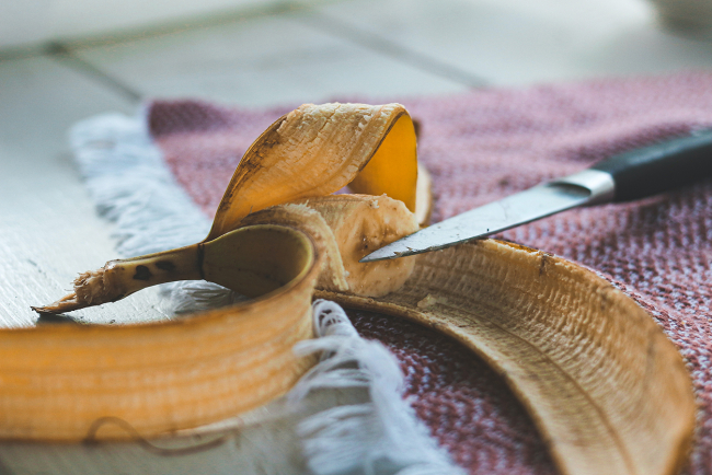 Alte angefangene Banane mit Messer