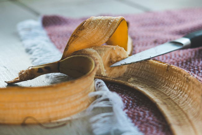 Ausstellung Foodwaste: Zeigt ein Bild einer geöffneten Banane mit angebräunter Schale und einem Messer