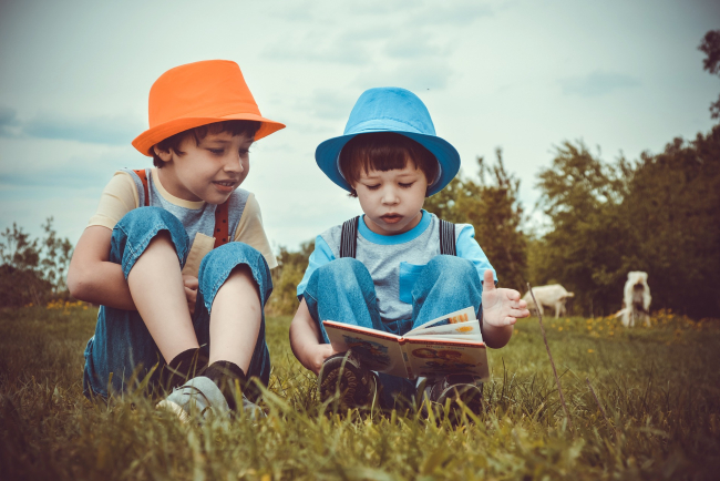 Lesende Kinder auf Wiese