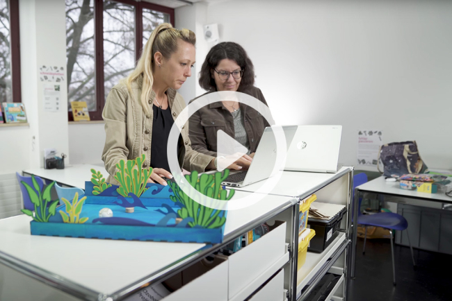 Zwei Frauen entwickeln einen analogen Prototypen und recherchieren dazu digital am Labtop