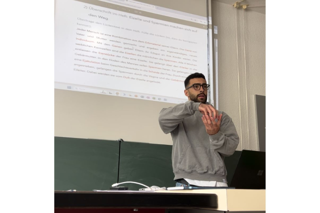 Filippo steht als Stellvertretung vor einer Schulklasse