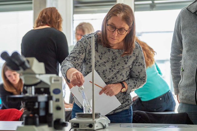 Frau wägt Reagenzglas ab