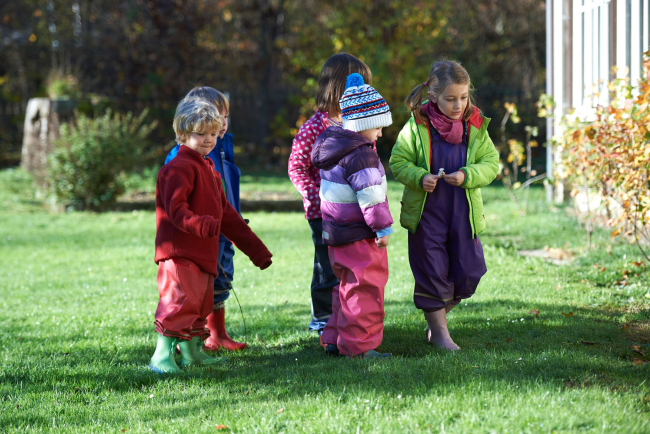 vier Kinder im Gras stehend