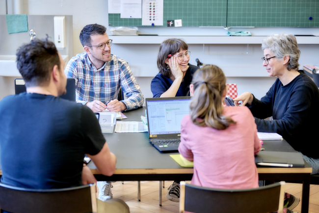 Lehrpersonenteam in lockerer Besprechung am Tisch