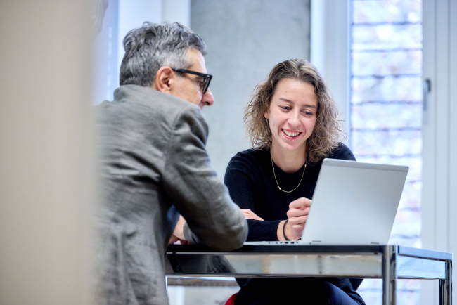 Mann und Frau an Labtop im Gespräch