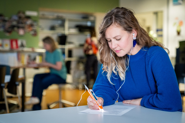 Frau mit Lesehilfe-Stift