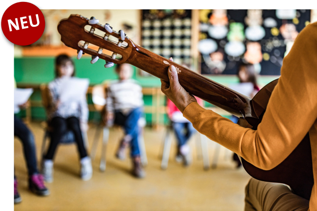 Detailaufnahme Hand an Gitarre von hinten, im Hintergrund Schulkinder