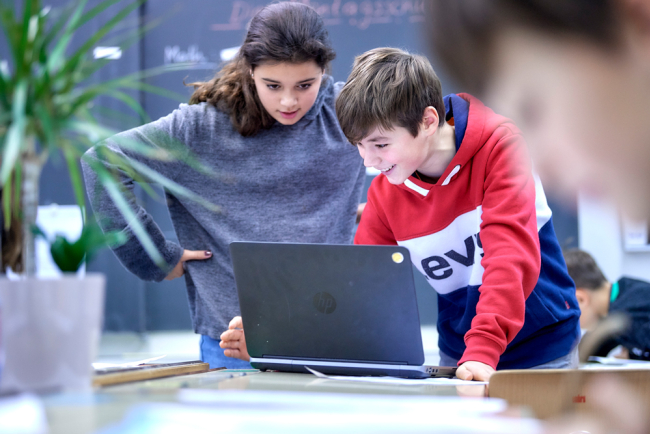 Schülerin  und Schüler im Unterricht am Labtop