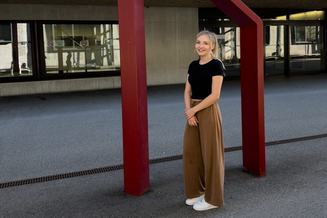 Studentin steht vor Skulptur