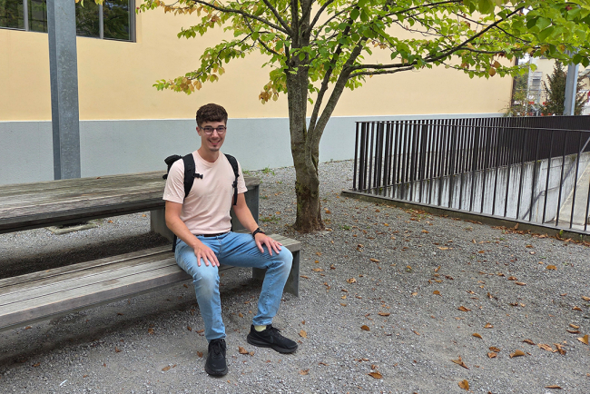 Ein Student sitzt auf einer Bank