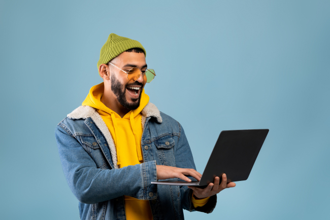 20261022_Symbolbild lachender Mann mit Laptop_Stock Adobe_Prostock-studio